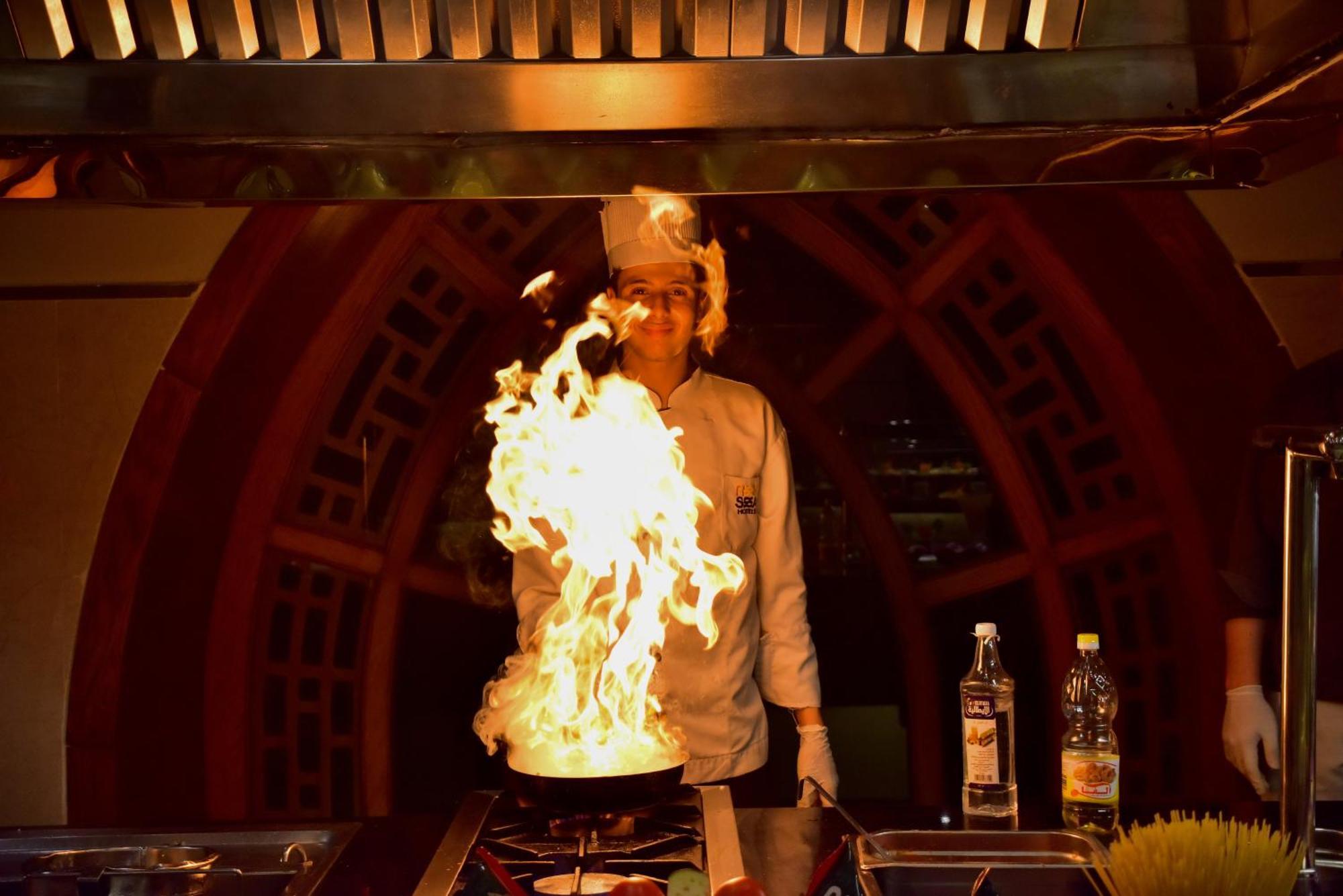 The Grand Hotel Sharm El Sheikh Екстериор снимка A chef cooking with a flaming wok